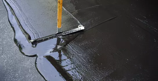 Application of pavement sealer to surface